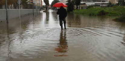 Un hombre camina en una calle anegada hoy en Dénia (Alicante).