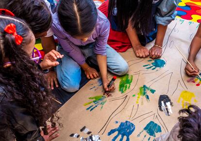 Un grupo de niños pinta un cartel con temática de Derechos Humanos