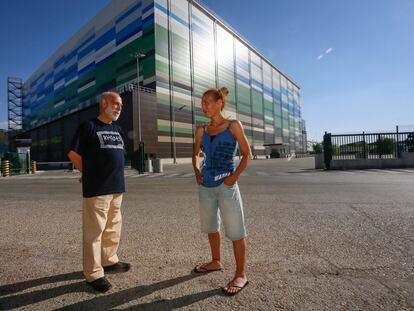 Francisco López, trabajador en una fábrica de Alcalá que cerró, y su hija Carmen, trabajadora en logística. Posan frente a una planta logística en la ciudad complutense.