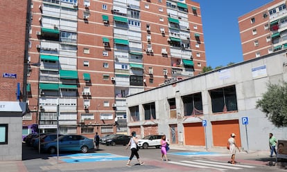 Cuatro personas cruzan un paso peatonal en la calle de Ginzo de Limia en el barrio del Pilar frente a una antigua comisaría en obras, el pasado 24 julio. El 12,2% de la población del barrio es extranjera.