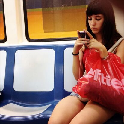 Una usuaria se conecta a internet con su móvil en un vagón del metro de Madrid.