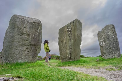 Mujer observando los menhires el Círculo Megalítico de Drombeg, conocido como El Altar del Druida y localizado en el condado de Cork.