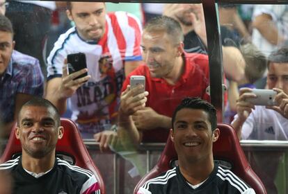 Pepe y Cristiano sonríen en el banquillo.