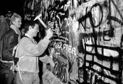 Los berlineses del Este cruzaron hacia el Oeste momentos después de la apertura del muro de Berlín en la medianoche del 9 de noviembre de 1989. En la imagen, un hombre rompe con un martillo una parte del Muro, cercana a la puerta de Brandenburgo, después de la caída de la frontera de la Alemania del Este.