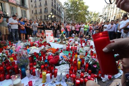 Una persona se dispone a colocar una vela en homenaje a las víctimas del atentado de Barcelona.