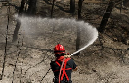 Un bombero francés refresca una zona quemada cerca de Marsella.