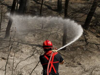 Un bombero franc&eacute;s refresca una zona quemada cerca de Marsella.