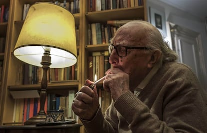 Andrea Camilleri s'encén un cigarro a la biblioteca de casa seva, a Roma.