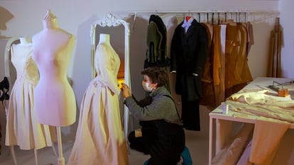 Una trabajadora coloca un traje durante los preparativos de la exposición 'Cornejo, el sastre de Galdós', en los Teatros del Canal en Madrid