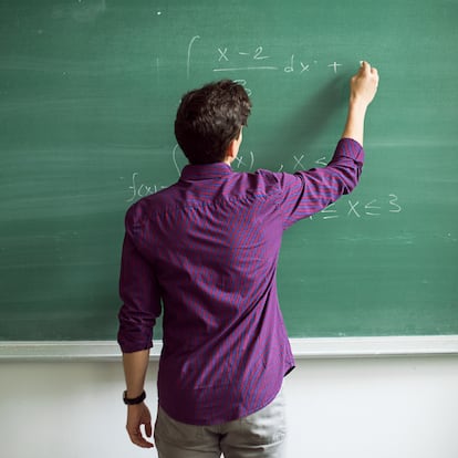 Student writing on blackboard