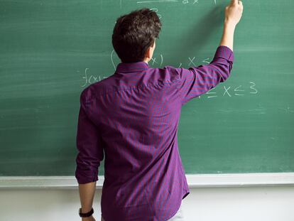 Student writing on blackboard