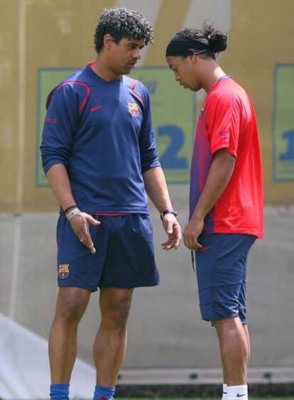 Rijkaard, a la izquierda, conversa con Ronaldinho.