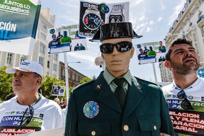 Dos hombres junto a un maniquí vestido de guardia civil en una concentración  de la plataforma que agrupa a una docena de organizaciones de Policía y Guardia Civil, frente al Congreso de los Diputados, este miércoles.