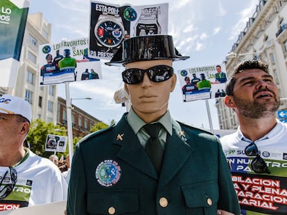 Dos hombres junto a un maniquí vestido de guardia civil en una concentración  de la plataforma que agrupa a una docena de organizaciones de Policía y Guardia Civil, frente al Congreso de los Diputados, este miércoles.