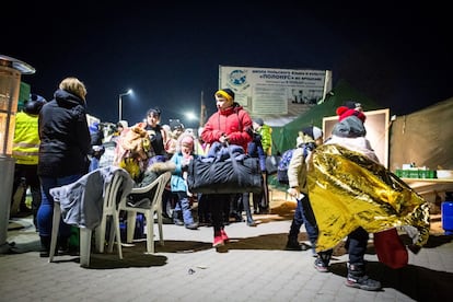 Un niño ucranio y su familia en el paso fronterizo de Medyka, cruzando la frontera con sus pertenencias en una fría noche en Polonia. Más de cinco millones de personas han dejado Ucrania desde el inicio de la invasión rusa, el 24 de febrero.