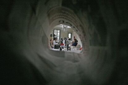La redacción de El 9 Nou, en Vic, vista desde un agujero formado por un ejemplar del periódico.