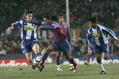 Ronaldinho avanza con el balón, acosado por Jarque (izquierda) e Ibarra, ante la mirada de Gio.