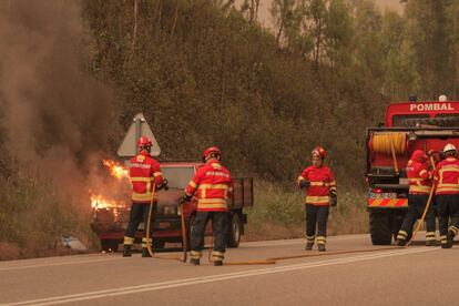 Els bombers intenten apagar un vehicle afectat per les flames a Pedrógão Grande.