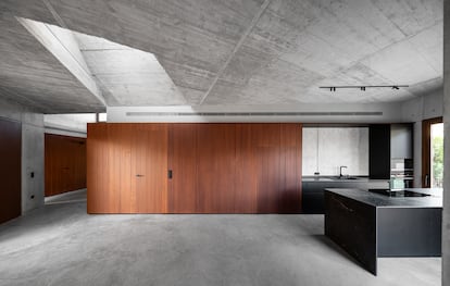 Las puertas correderas de madera separan el interior de Casa Sinapsis y esconden los baños y la cocina.