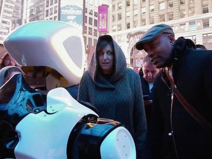 Varias personas interactúan con un robot en Times Square.