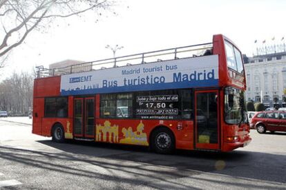 Un autobús turístico gestionado por la EMT circula por el Paseo del Prado.