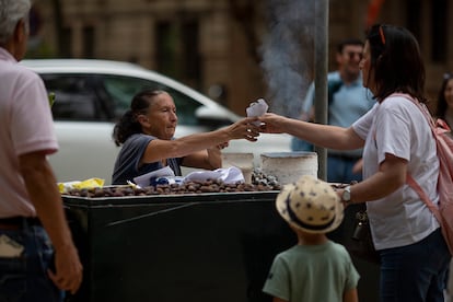 Una mujer vende castañas asadas en un puesto callejero de Sevilla, este martes.