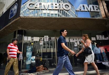 Un grupo de transeúntes frente a una casa de cambio de Buenos Aires.