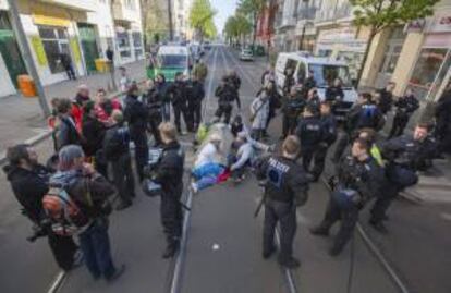 Un grupo de activistas se encadenan a un bloque de cemento con la intención de interrumpir la manifestación del neonazi Partido Nacionaldemócrata (NPD), en una calle del barrio Schöneweide de Berlín, en Alemania.