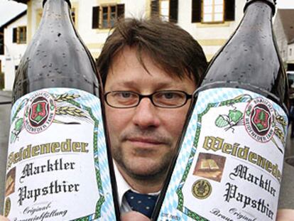 Un alemán enseña dos botellas de la <i>Papstbier,</i> la cerveza del Papa.