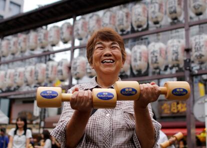 Una mujer realiza ejercicios con mancuernas de madera durante un evento a favor del respeto por los ancianos, el 19 de septiembre, en un templo de Tokio (Japón). 