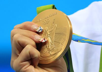 La mano de la española Mireia Belmonte sujetando la medalla de oro. 