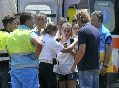 Una mujer (c) preguntando al personal de rescate si tiene información acerca de su hijo, que estaba viajando en uno de los trenes implicados en el accidente que tuvo lugar cerca de la localidad de Andria, en Italia. 