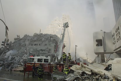 New York City firefighters work at the World Trade Center after two hijacked planes crashed into the Twin Towers.
