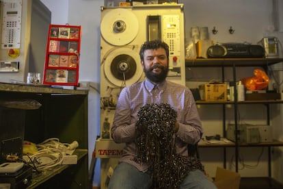 Luis, el dueño de la tienda La Cassetería posa con restos de cintas en su tienda en Madrid.
