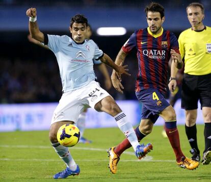 Augusto Fernández protege el balón ante Cesc.