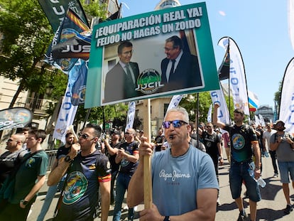 Un manifestante sujetaba este sábado una pancarta con una foto de Feijóo con el exministro Zoido, durante la protesta policial en Madrid.