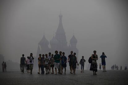 Rusia sigue sufriendo los efectos devastadores de unos incendios que, cinco días después de desatarse, han dejado 50 muertos y a miles de personas en la calle. También son desastrosas las consecuencias económicas, simbolizadas por la cancelación de la exportación de trigo. En la imagen, unos turistas intentan distinguir los edificios emblemáticos de la Plaza Roja de Moscú a través del denso humo.