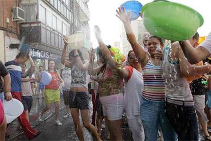 Vecinos de Vallecas se remojan durante la <i>batalla naval</i> celebrada ayer por las calles del distrito.