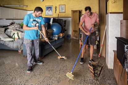 Dos vecinos limpian el interior de su vivienda en la localidad de Dolores, Alicante.