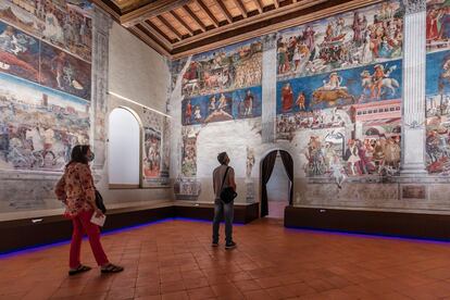Varios visitantes observan los frescos en las paredes del Museo Schifanoia.