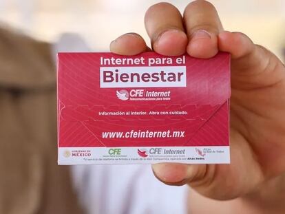 Un hombre sostiene una tarjeta de Internet para el Bienestar.