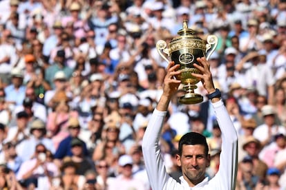 El tenista Novak Djokovic levanta el trofeo después de derrotar al australiano Nick Kyrgios en la final de tenis masculino del Campeonato de Wimbledon en Londres.