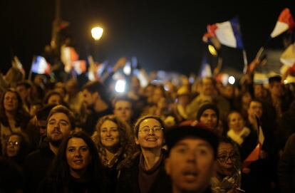 Seguidores de Macron siguen su discurso en la plaza del Louvre.