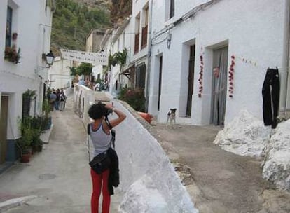 Un grupo de visitantes recorre la calle de los Molinos en el pueblo albaceteño de Molinicos.