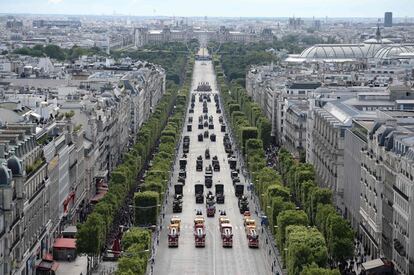 El desfile anual del Día de la Bastilla con la noria Grande Roue de fondo en la avenida de los Campos Elíseos en París, Francia. 