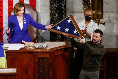 Zelenski muestra la bandera de EEUU que ha recibido como obsequio.  