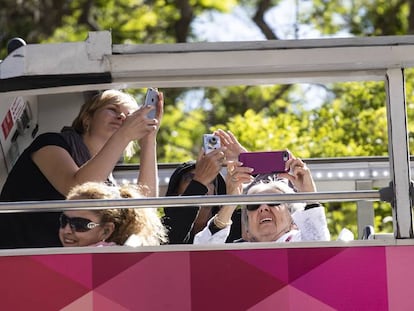 Turistas haciendo fotos en la Sagrada Familia desde un autobús.