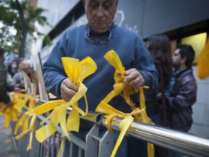 A man removes yellow ribbons from a public space in Catalonia.