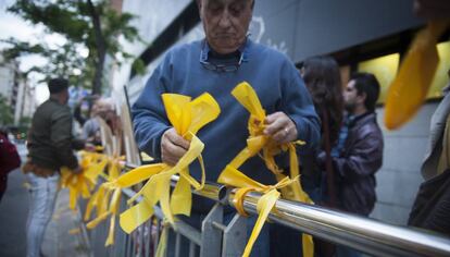 A man removes yellow ribbons from a public space in Catalonia.