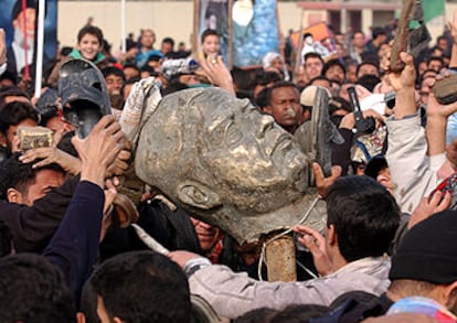 Fieles chiíes golpean un busto de bronce de Sadam Husein tras el rezo del viernes en Ciudad Sadr, en Bagdad.